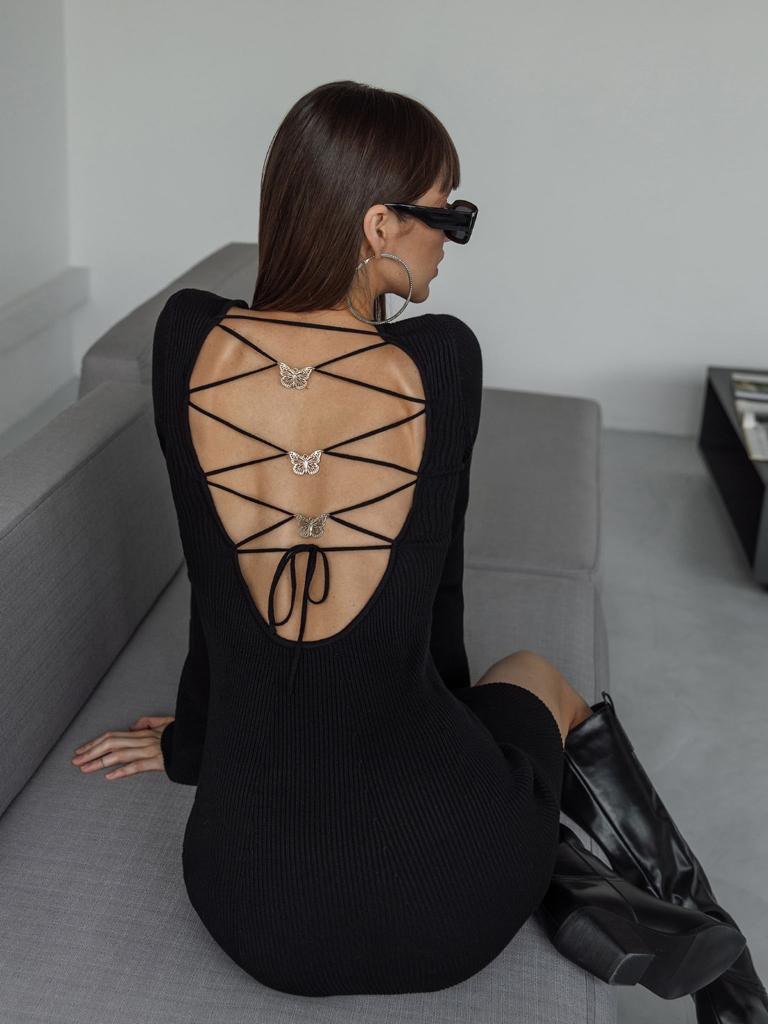 Γυναικείο μίντι πλεκτό φόρεμα με ανοιχτή πλάτη και μεταλικές πεταλούδες διακοσμητικές στην πλάτη Ελαστικό ύφασμα πλεκτό σε χρώμα μαύρο