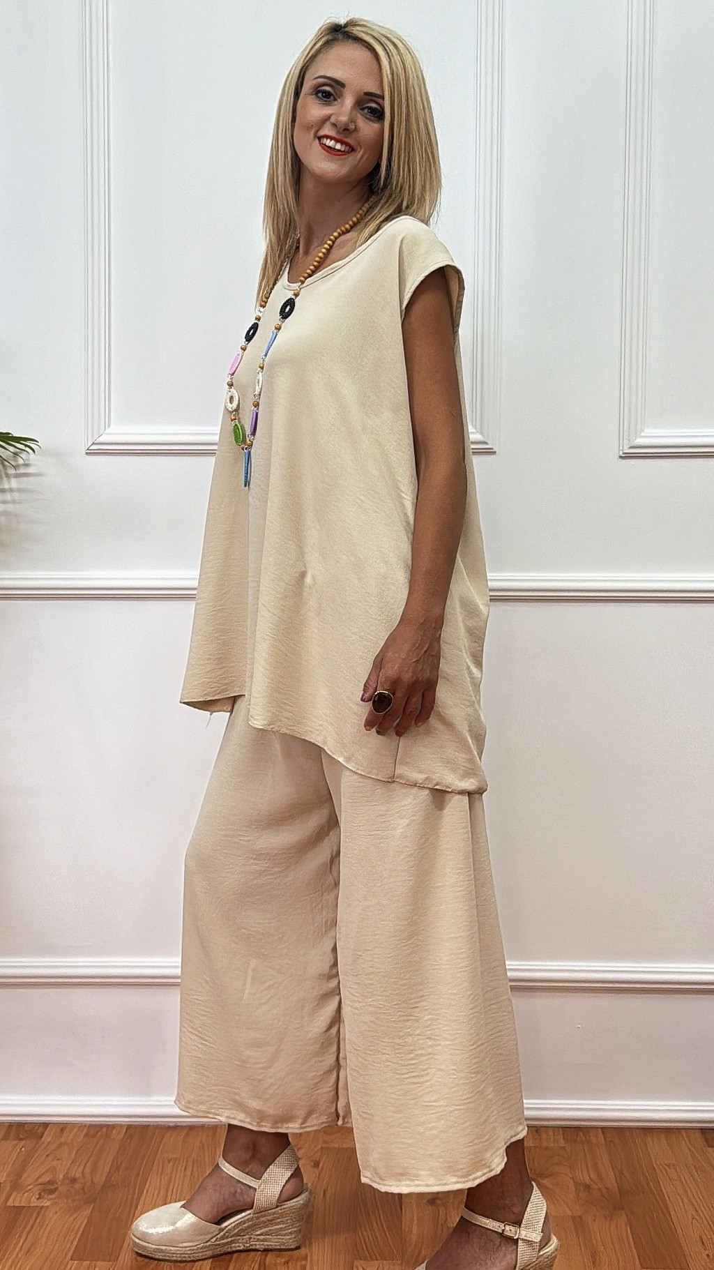 Σετ Παντελόνα & Αμάνικη μπλούζα Μπεζ (Beige) Το παντελόνι ζιπ κιλοτ με λάστιχο στη μέση Η μπλούζα σε Α γραμμή αμάνικη με κολιέ. Μέχρι 2xl Plus size