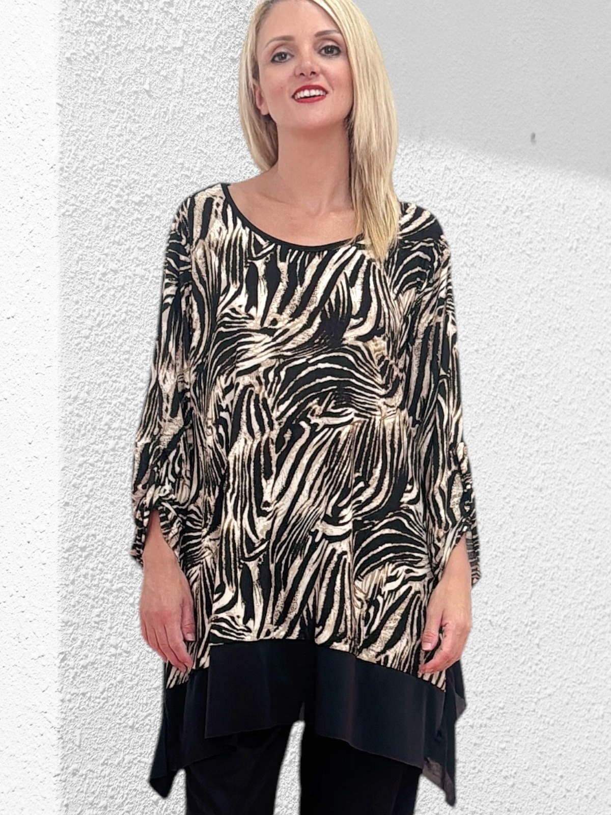 Μπλούζα σε άλφα γραμμή με εντυπωσιακό animal print . Διαθέτει ανοιχτή λαιμόκοψη και κομψή διχρωμία στο κάτω μέρος. Κατασκευασμένη από απαλό, βουτυράτο ύφασμα, είναι ιδανική και για μεγάλα μεγέθη, προσφέροντας άνεση και στυλ σε κάθε εμφάνιση.