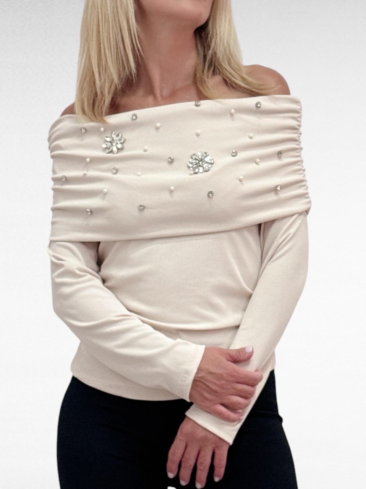 Strapless μακρυμάνικο τοπ σε εκρού με φαρδιά μπάσκα στο μπούστο, διακοσμημένη με κοσμήματα και πέρλες για extra glam. Η ελαστική μπάσκα αγκαλιάζει το σώμα για τέλεια εφαρμογή. Ιδανικό για chic εμφανίσεις με στυλ!