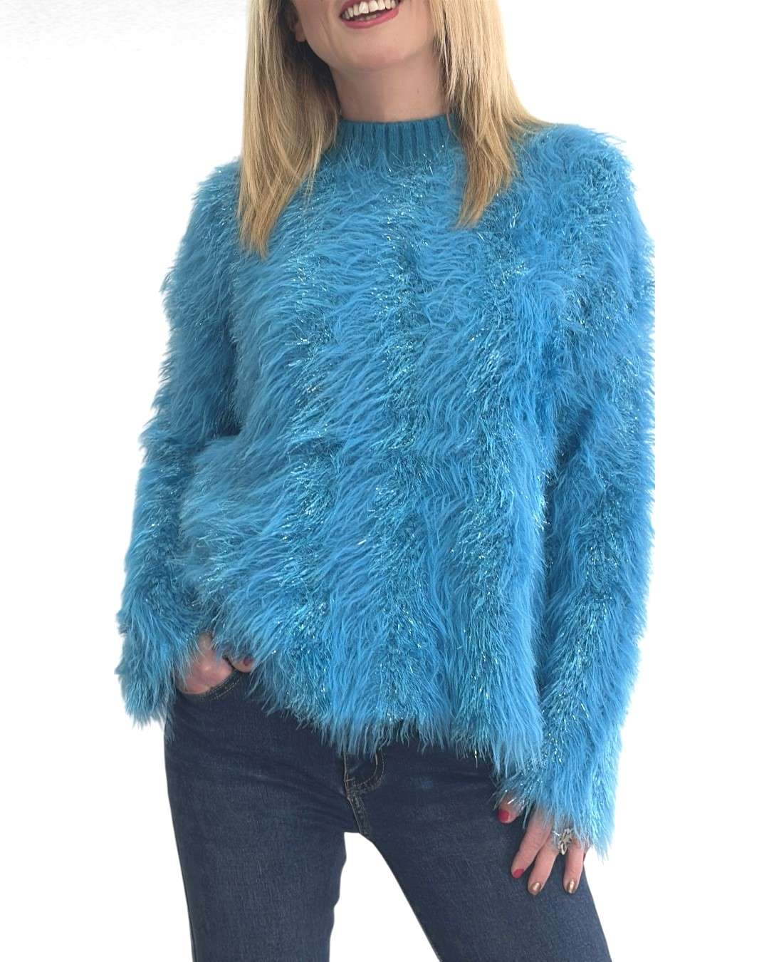 Χνουδωτό πουλόβερ με κρόσσια Μπλε fluffy Κατασκευασμένο από fluffy πλεκτό ύφασμα, προσφέρει εξαιρετική απαλότητα και ευχάριστη αίσθηση στην αφή. Διαθέτει διακριτική λάμψη χάρη στη lurex κλωστή στον ίδιο τόνο, προσθέτοντας μια πινελιά πολυτέλειας.