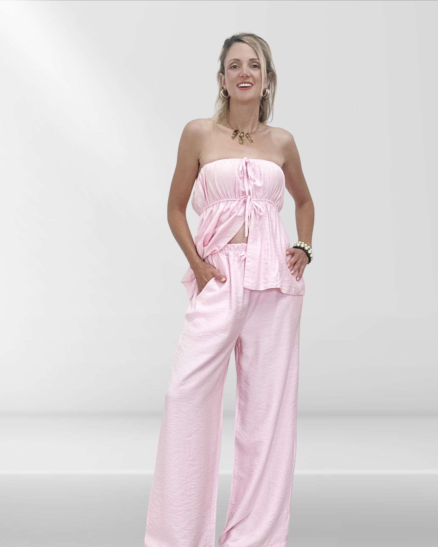 Άνετο και στιλάτο γυναικείο σετ με παντελόνα και στράπλες τοπ με λάστιχο. Μονοχρωμία, one size εφαρμογή για S έως L. Σε χρώμα ροζ