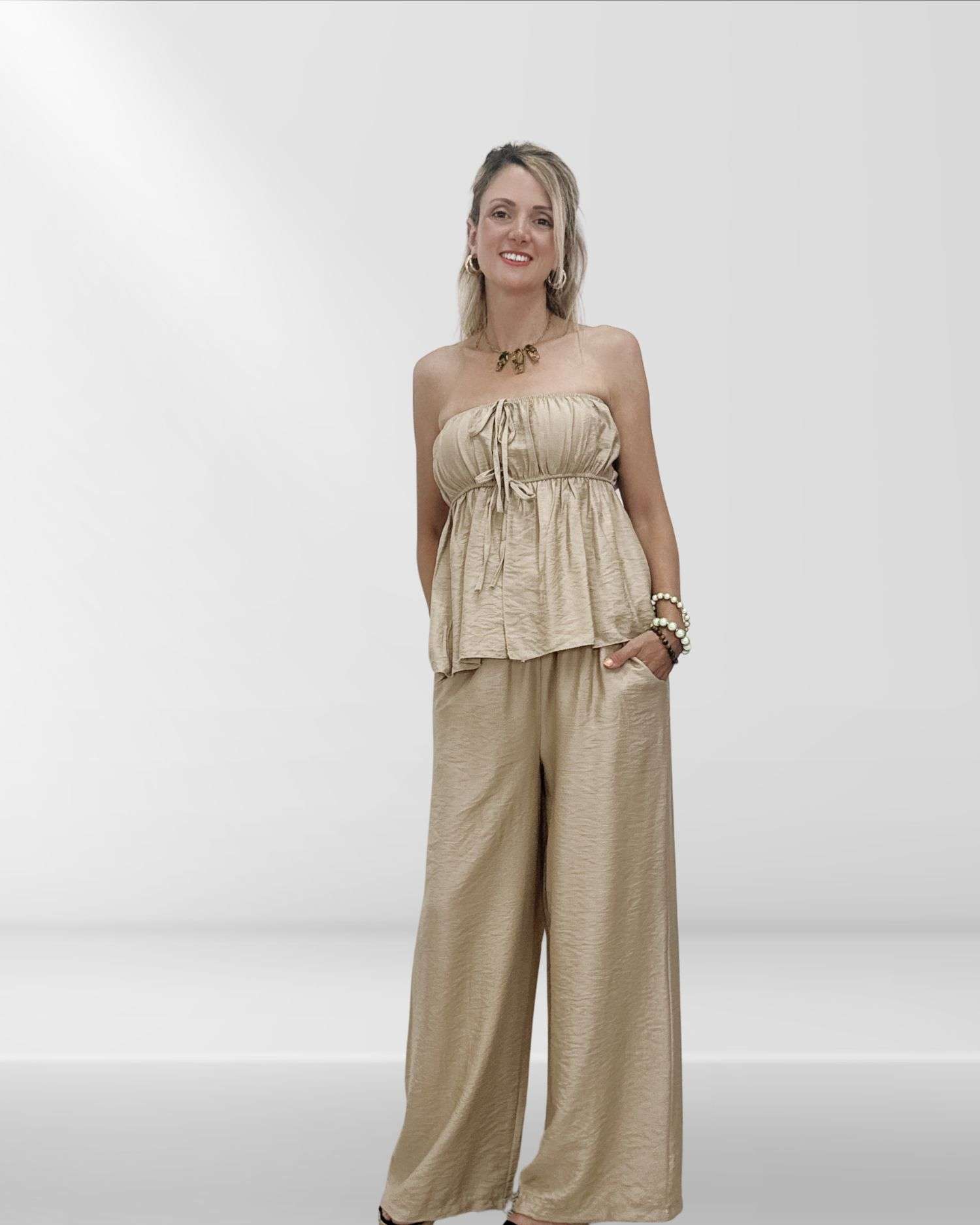 Άνετο και στιλάτο γυναικείο σετ με παντελόνα και στράπλες τοπ με λάστιχο. Μονοχρωμία, one size εφαρμογή για S έως L. Σε χρώμα μπεζ