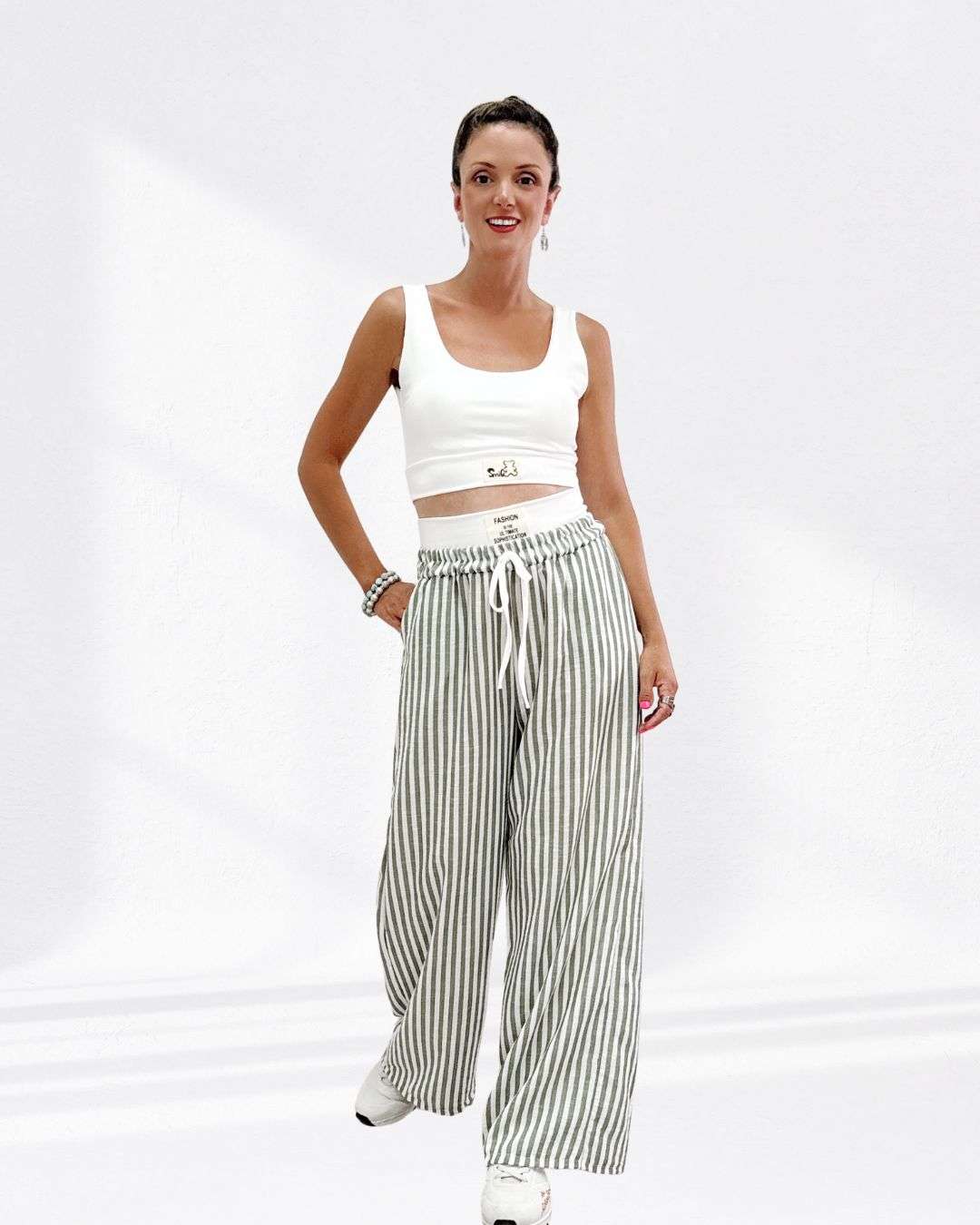 Σετ με Μπουστάκι & Ριγέ Παντελόνα Λαδί Μπουστάκι με ενίσχυση (cups) για σταθερό κράτημα και άνεση, καλύπτει στήθος 90εκ Φαρδιά παντελόνα καλύπτει μέση 100 εκ. και περιφέρεια έως 110 εκ. – για ελευθερία κινήσεων και stylish look. Ριγέ ύφασμα και στο παντελόνι έχει λευκή λεπτομέρεια για extra twist. Λάστιχο στη μέση και πλαϊνές τσέπες για πρακτικότητα και cool χαρακτήρα.