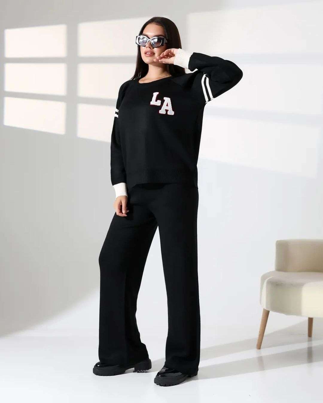 Πλεκτό σετ με με κέντημα LA Μαύρο Πλεκτό σετ δύο τεμαχίων με cozy πουλόβερ και άνετη παντελόνα. Η μπλούζα σε μαύρο χρώμα διαθέτει statement κέντημα LA και διχρωμίες που δίνουν μοντέρνο, sporty χαρακτήρα. Καλύπτει στήθος μέχρι 120-125 εκ και έχει μήκος 60εκ. από τον ώμο. Μονόχρωμο μαύρο παντελόνι σε άνετη γραμμή για εύκολους συνδυασμούς Καλύπτει μέση ως 115-120 εκ και περιφέρεια ως 115-120 εκ Μήκος 106 εκ