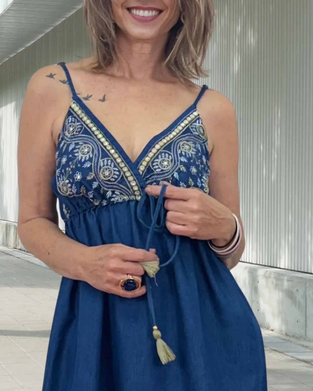Maxi denim φόρεμα με λεπτές ρυθμιζόμενες τιράντες και κέντημα στο μπούστο που δίνει boho χαρακτήρα. Λάστιχο στην πλάτη για άνετη εφαρμογή και δέσιμο κάτω από το στήθος.  Πλαϊνά σκισίματα για κίνηση και θηλυκότητα. Fit: Αέρινη γραμμή που ανοίγει προς τα κάτω. Ύφασμα: 100% Cotton. 