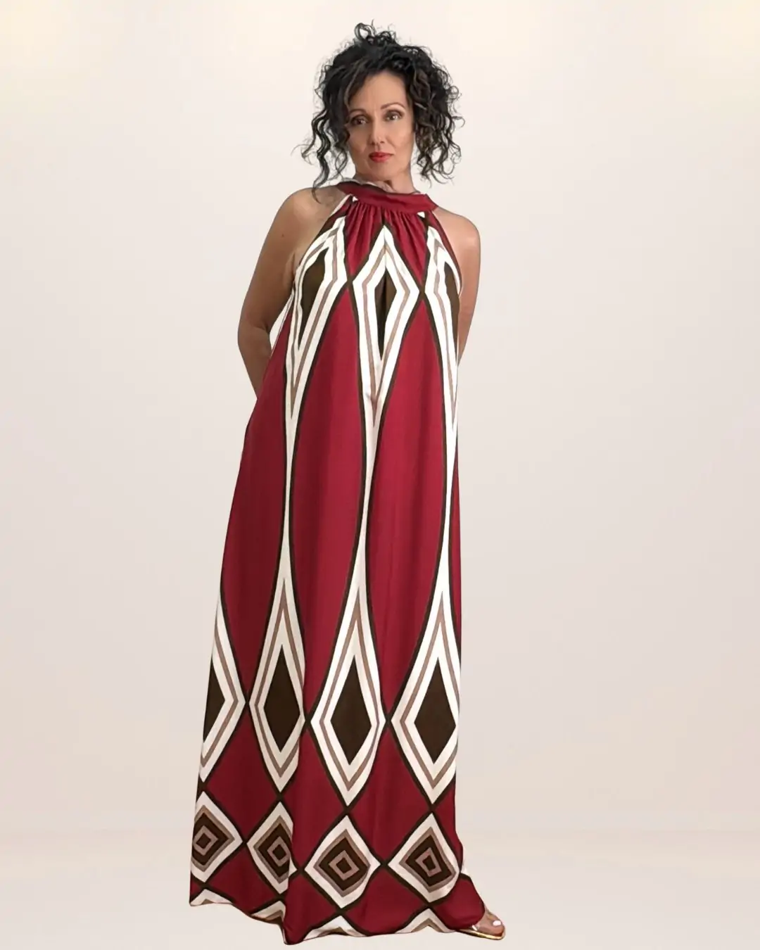 maxi γυναικείο καλοκαιρινό φόρεμα σε δροσερή viscose. Ανοιχτοί ώμου, δένει πίσω με κορδόνι στο λαιμό και έχει γεωμετρικά σχέδια τύπωμα που του δίνει boho και retro chic χαρακτήρα Το βασικό χρώμα είναι κόκκινο κεραμιδί